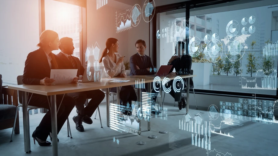 People sitting in an office with charts on the screen